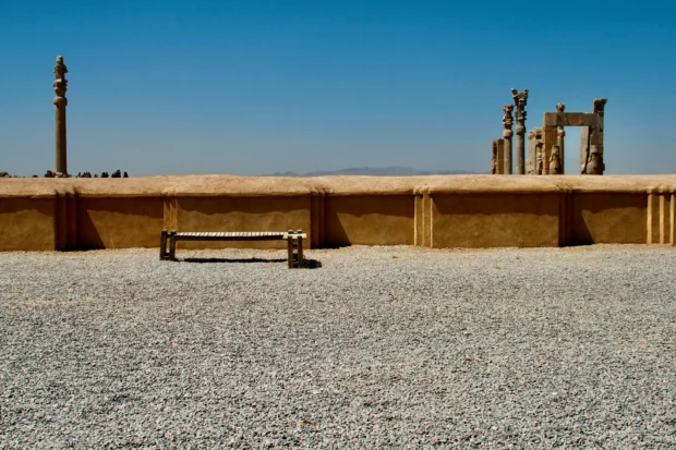 Columns at Persepolis with a bench in front of them.