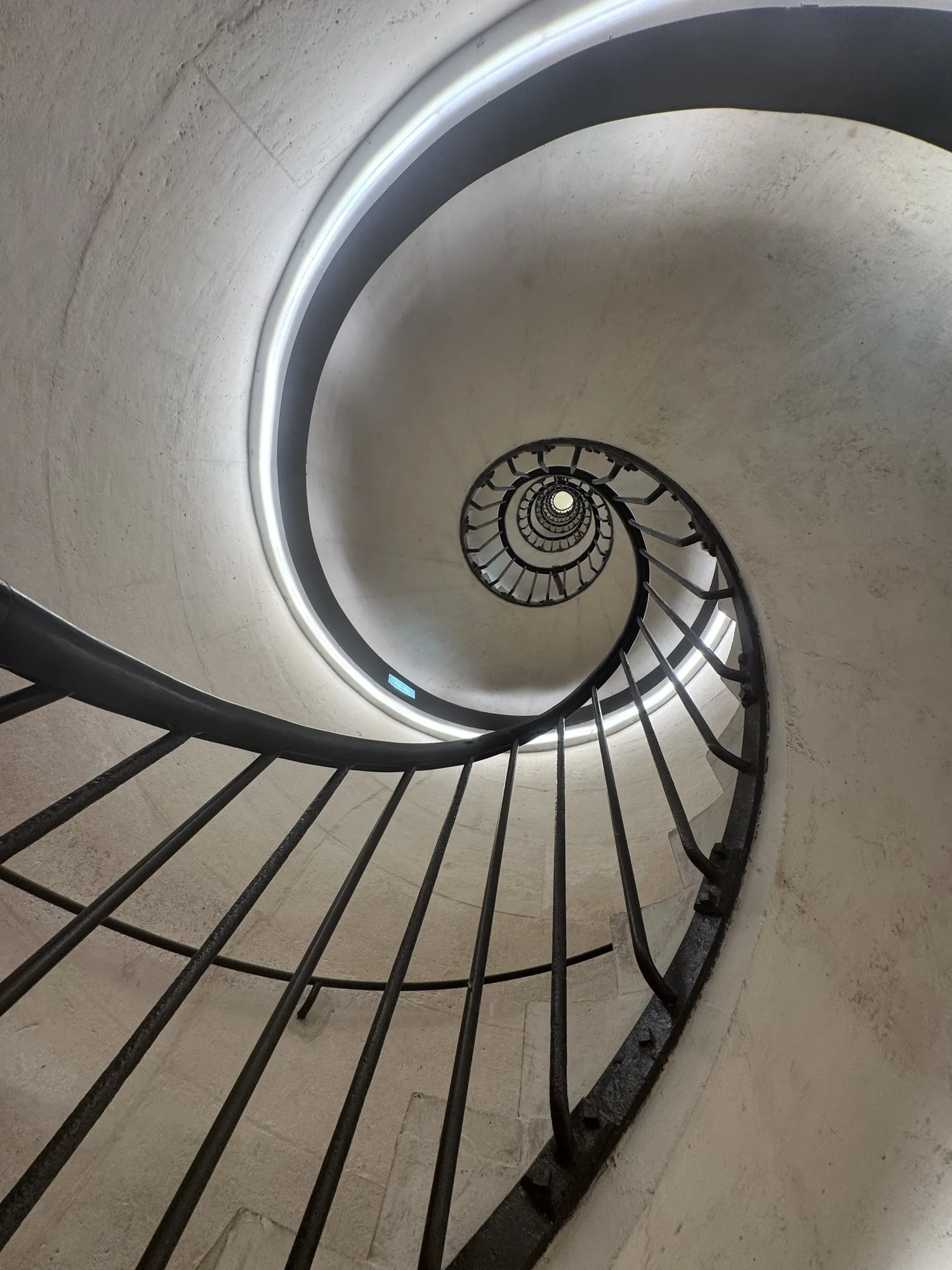 A spiral staircase seen from above, winding down to a point.