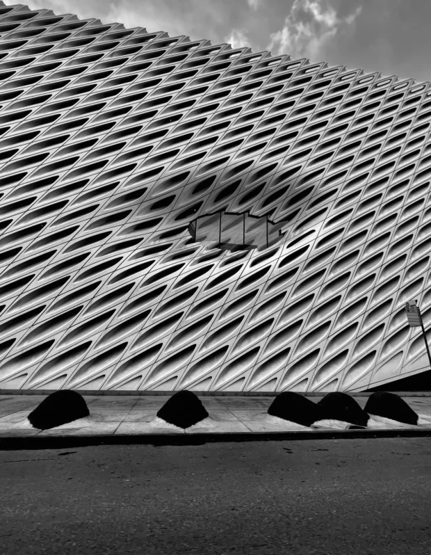 The diagonal lattice skin of the Broad, Los Angeles, with the canopies along its base.