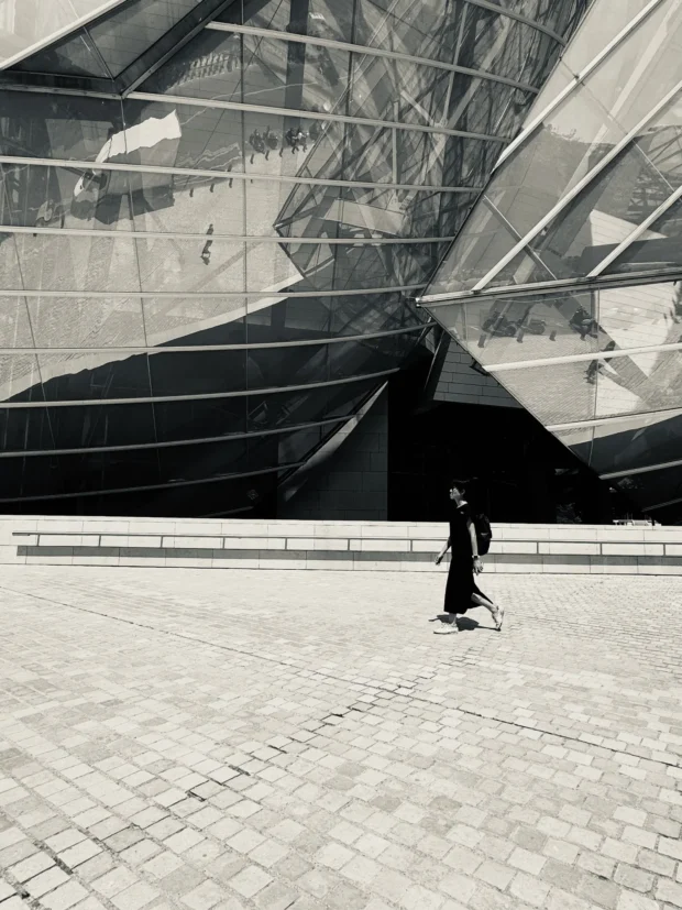 The same black sail with one figure in a dark coat against it.