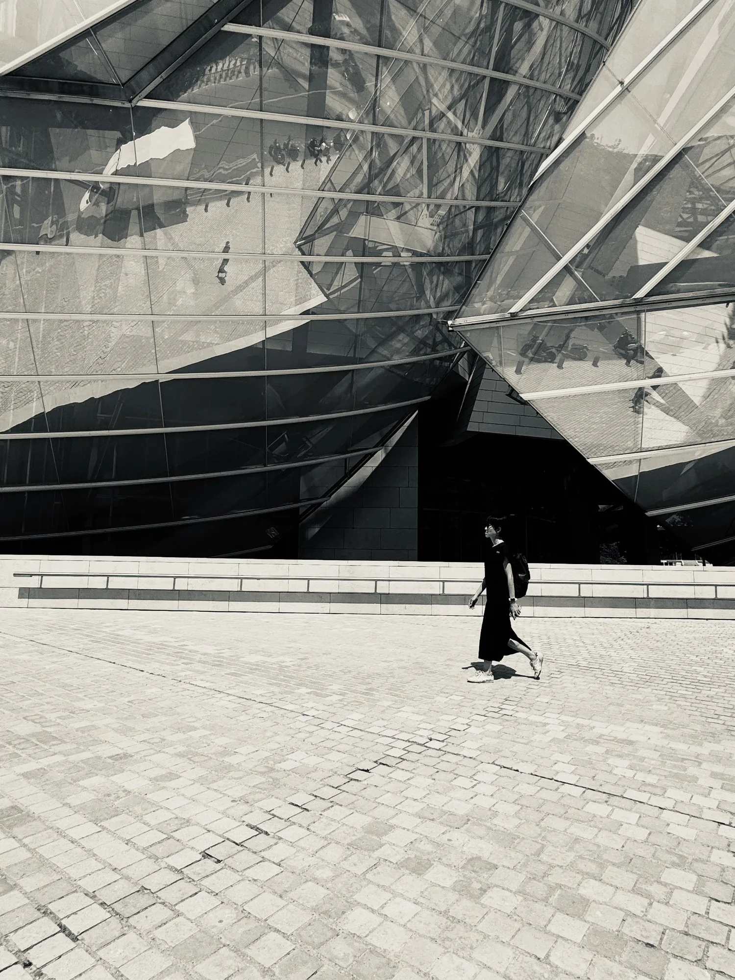 The same black sail with one figure in a dark coat against it.