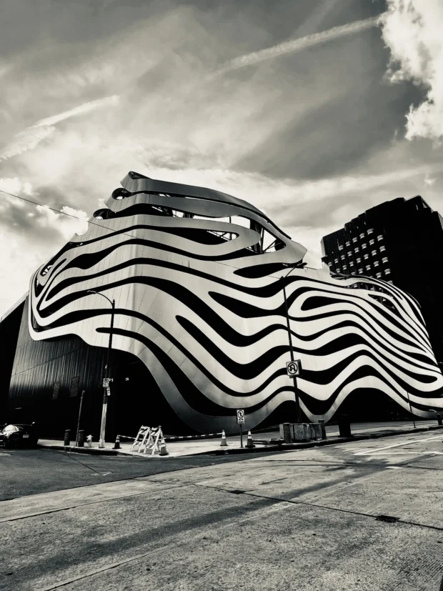 The steel ribbons of the Petersen Museum against cloud, black and white.