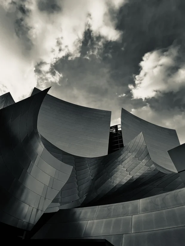 The steel panels of Disney Hall against cloud, black and white.