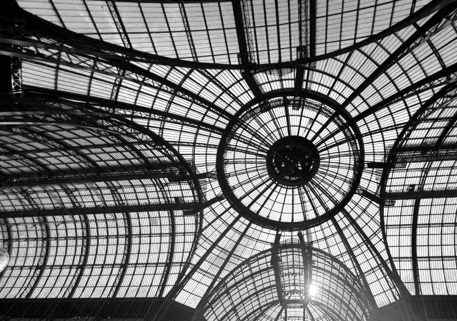 The Grand Palais glass dome from directly below, the steel radiating out with the sun burst through it.