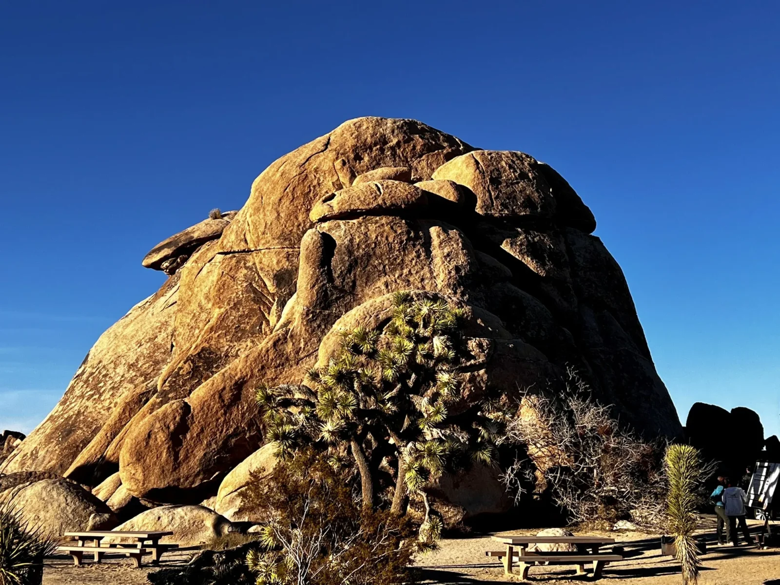 A rock dome against blue with the road under it.