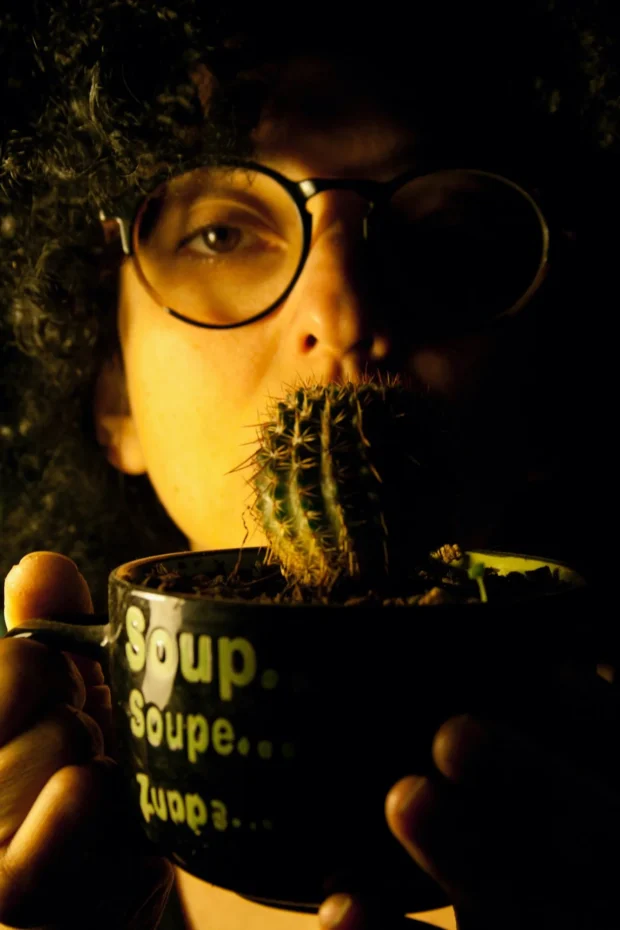 A cactus in a soup mug held up to the mouth.
