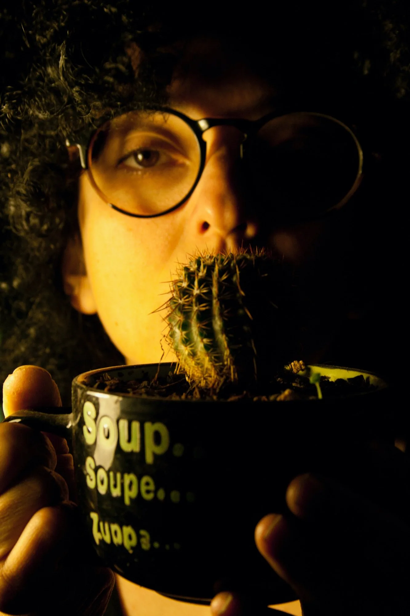 A cactus in a soup mug held up to the mouth.