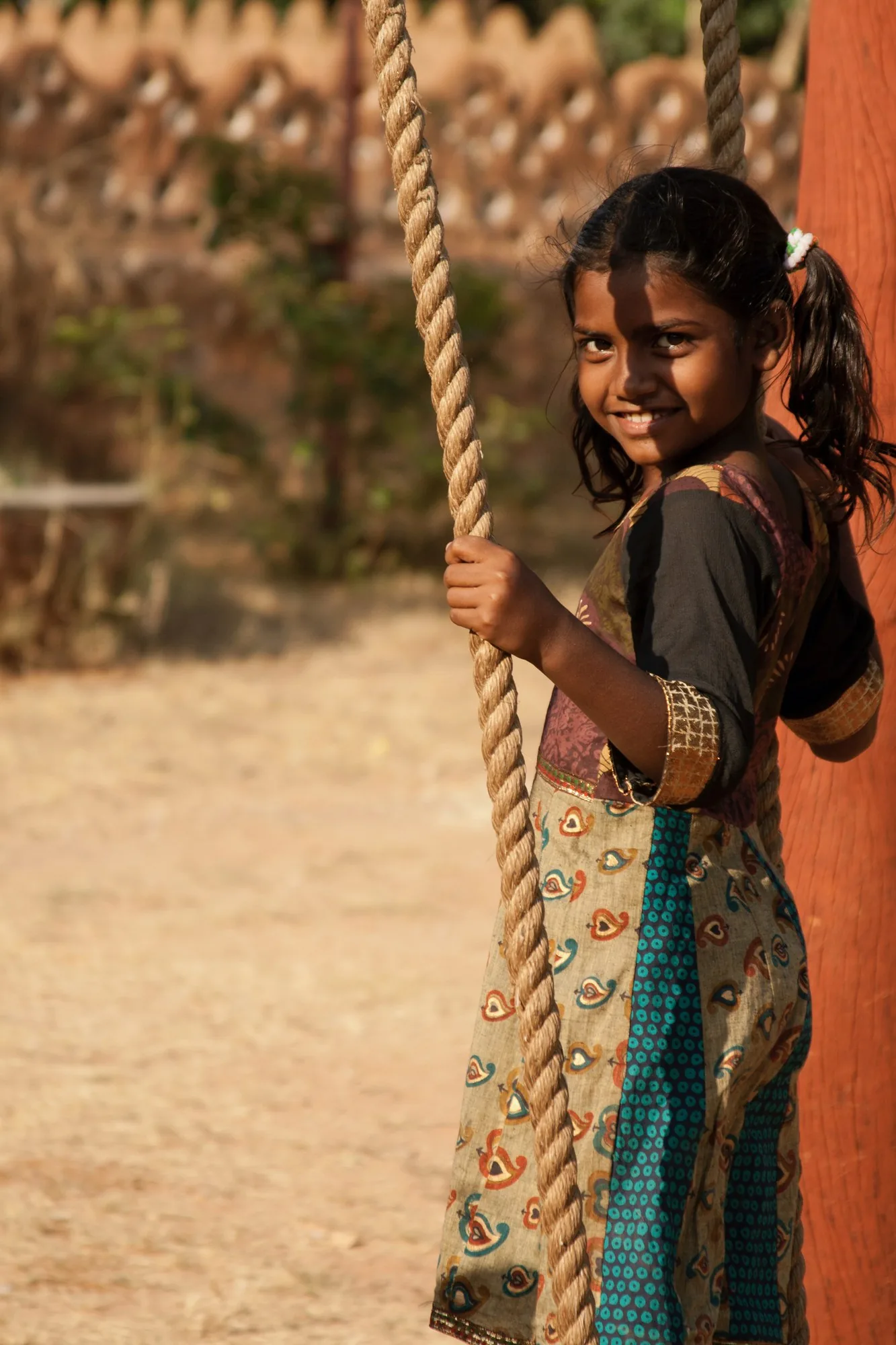 A girl beside a rope swing.