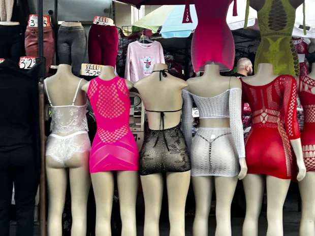 The mannequins, ranked along a market stall.
