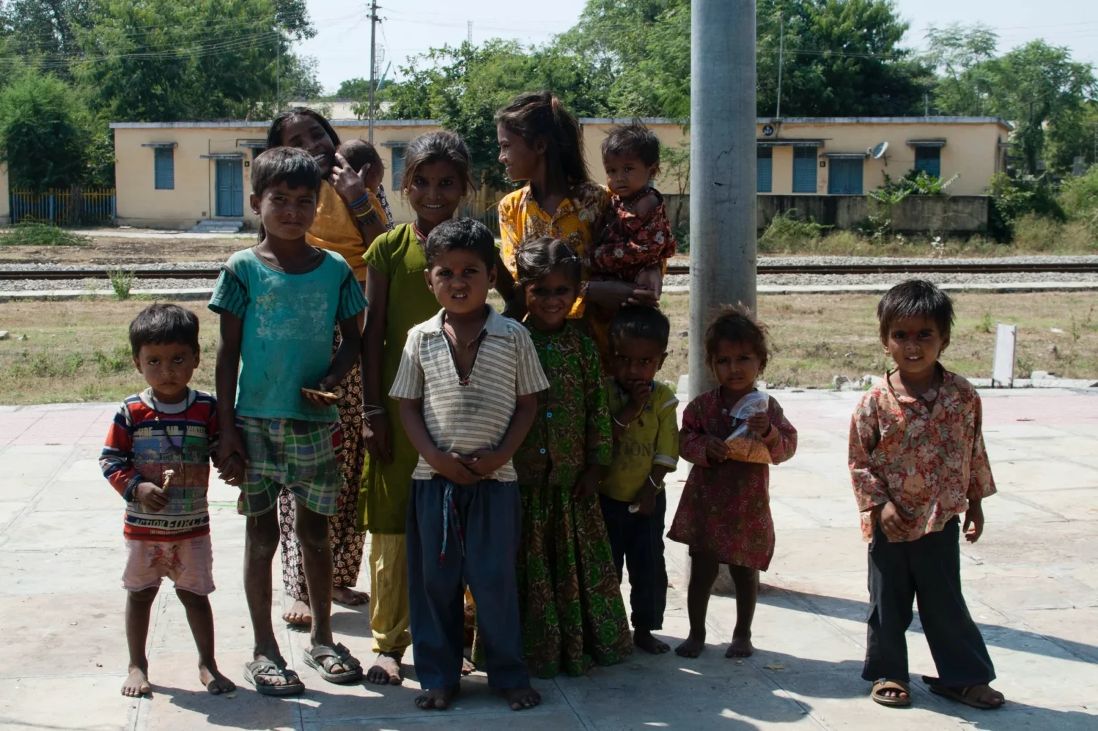 The whole group lined up by the railway, the station buildings behind.