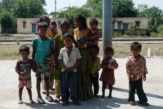 The whole group lined up by the railway, the station buildings behind.
