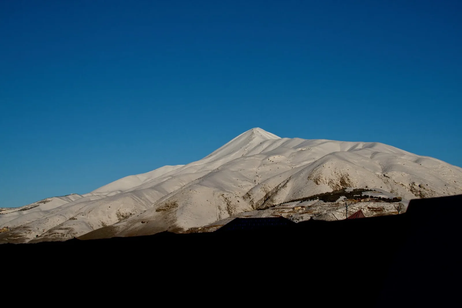 A white peak over a solid black foreground.