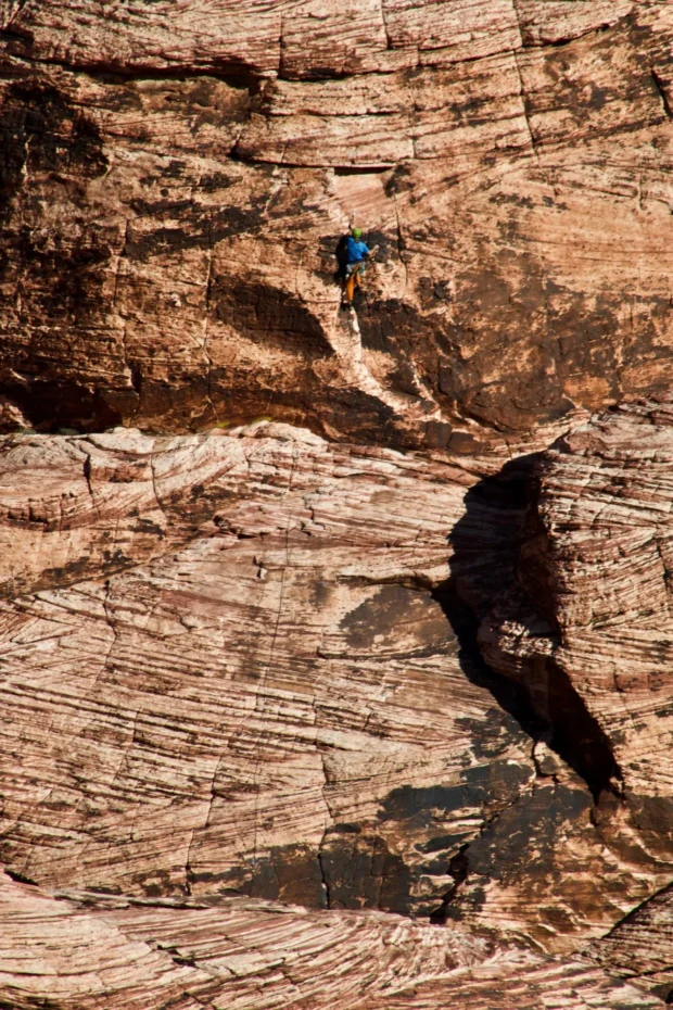 Cross-bedded sandstone with one climber and a hard black shadow.